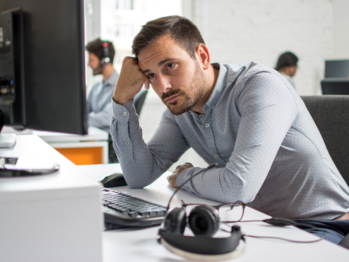 Worried beard man looking at computer screen in office Coaching - erschöpfter Mann